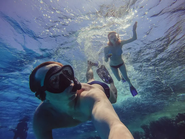 Snorkeling O cara e a menina nadam com um cachimbo e uma máscara — Fotografia de Stock