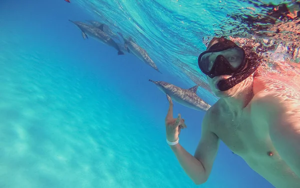 Yunuslarla selfie çekmek. Adam açık se yunuslar ile yüzer — Stok fotoğraf