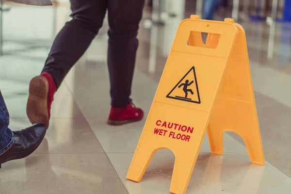 The plate is wet floor. People walk on the wet floor.