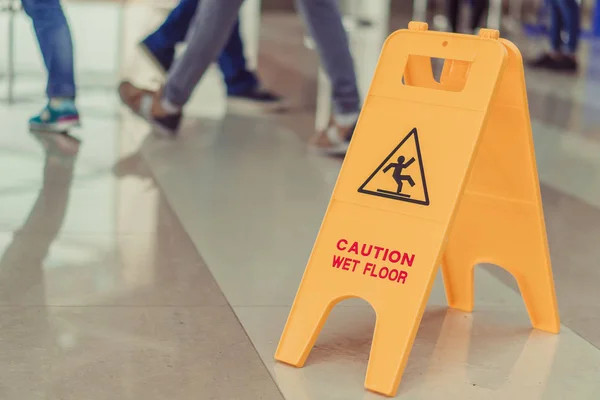 The plate is wet floor. People walk on the wet floor.