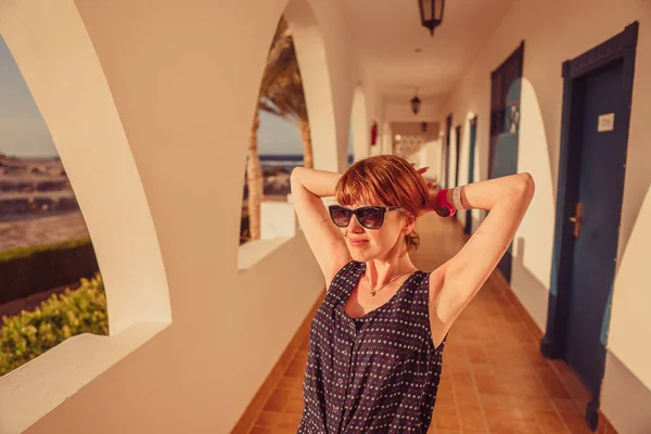 Una chica se para cerca de la ventana y marca un número de teléfono en un mobi — Foto de Stock