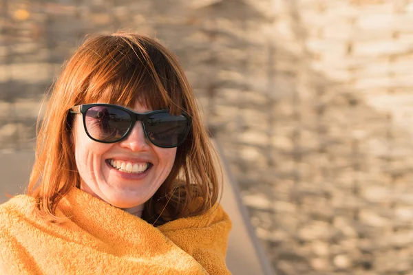 En flicka i solglasögon tittar på havet, silhuetter av peopl — Stockfoto