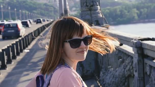 一个女孩站在桥上 她的头发被风吹得膨胀 — 图库视频影像