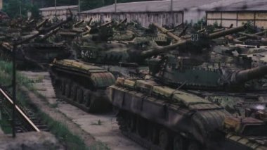Mezarlık askeri teçhizatı. Dikenli tel depo paslı tankları altında