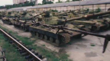 Mezarlık askeri teçhizatı. Dikenli tel depo paslı tankları altında