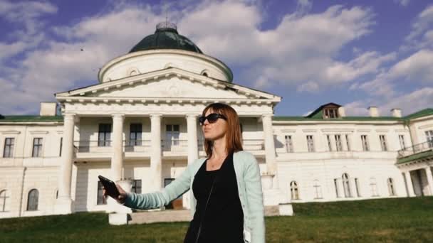 携帯電話で自分撮り 少女は歴史的な宮殿の背景に自分自身を解放します — ストック動画