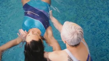 Watsu. Alternatif tıbbın yönü, ılık suda tedavi şekli. Usta Watsu bir genç kız için bir terapi oturumu yürütmektedir.