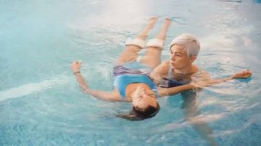 Watsu. Alternatif tıbbın yönü, ılık suda tedavi şekli. Usta Watsu bir genç kız için bir terapi oturumu yürütmektedir.