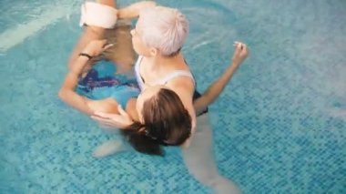 Watsu. Alternatif tıbbın yönü, ılık suda tedavi şekli. Usta Watsu bir genç kız için bir terapi oturumu yürütmektedir.