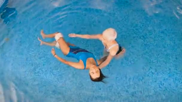 Watsu 의학의 따뜻한 물에서치료의 마스터 와츠는 소녀를위한 세션을 실시합니다 위에서 — 비디오