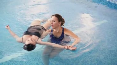 Watsu. Alternatif tıbbın yönü, ılık suda tedavi şekli. Master Watsu bir kadın için bir terapi oturumu yürütmektedir. 