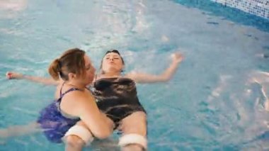 Watsu. Alternatif tıbbın yönü, ılık suda tedavi şekli. Master Watsu bir kadın için bir terapi oturumu yürütmektedir. 