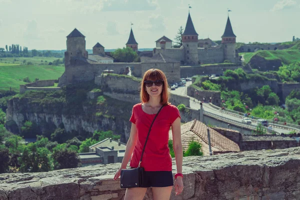 The girl is photographed against the background of the castle. T — Stock Photo, Image