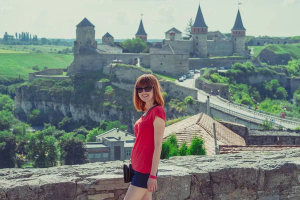 The girl is photographed against the background of the castle. T — Stock Photo, Image