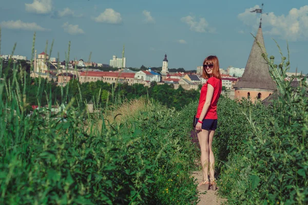 La chica es fotografiada sobre el fondo del castillo. T — Foto de Stock