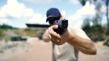 Çekim. Bir adam atış poligonunda tabancayla taktik atış yapıyor..