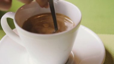 Kahve. El bir fincan kahve şeker ile bir kaşık karıştırır