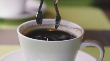 Kahve ve şeker. Rafine kahve kahvenin içine atılır..