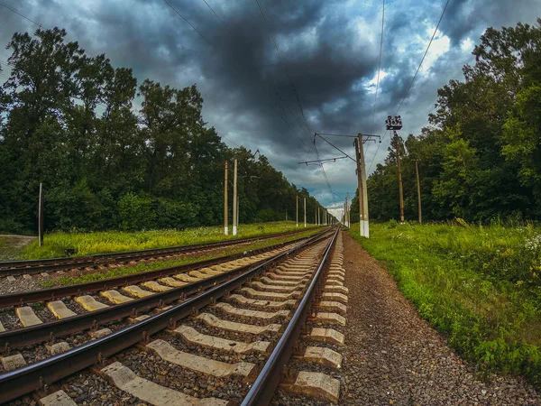 Spoorlijn op een achtergrond van donkere wolken — Stockfoto