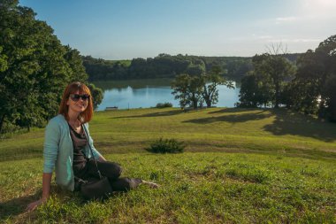 Doğa. Nehir kenarında oturan kız