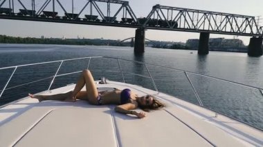 Yat. Mayo giyen bir kız yat güvertesinde güneşleniner..