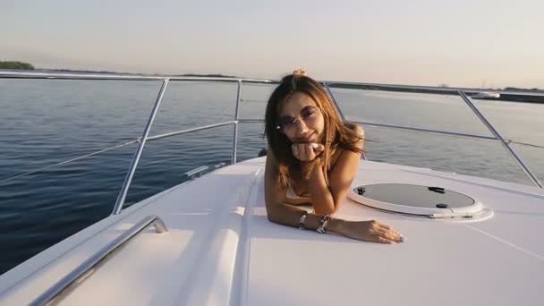 一个穿着泳衣的女孩在游艇的甲板上晒日光浴 — 图库视频影像