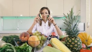 Sebzeli mutfak. Bir kız mutfakta duruyor ve elinde bir avokado tutar.