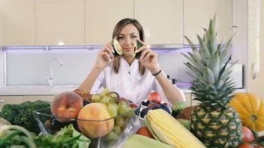 Sebzeli mutfak. Bir kız mutfakta duruyor ve elinde bir avokado tutar.