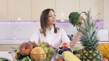 Mutfak ve sebzeler. Kız elinde brokoli tutar.