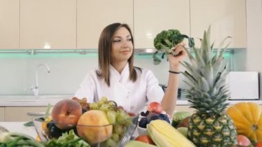 Mutfak ve sebzeler. Kız elinde brokoli tutar.