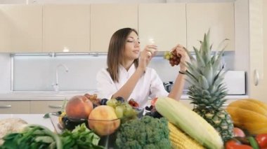 Mutfak ve yemek. Kız elinde üzüm tutar.