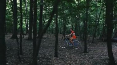 Kadın bisikleti. Ormanda bir kadın bisikletle ayakta duran bir kadın..