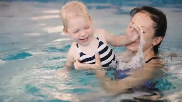 游泳池 妈妈教一个小孩在游泳池里游泳 — 图库视频影像