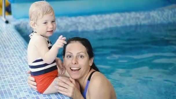 游泳池 妈妈教一个小孩在游泳池里游泳 — 图库视频影像