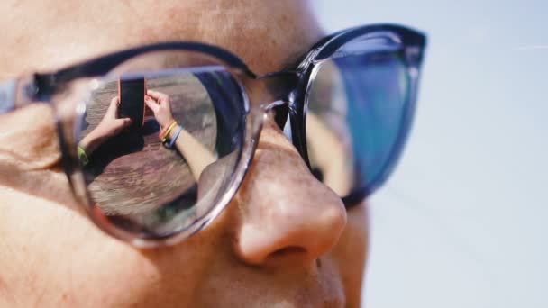Telemóvel Uma Mulher Óculos Sol Olha Para Telemóvel — Vídeo de Stock