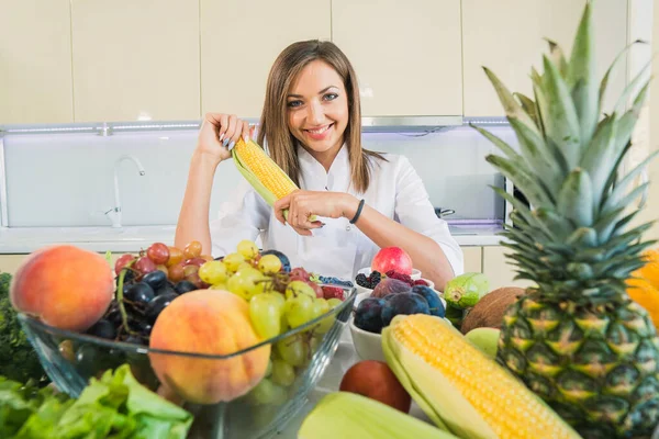 Maíz. Una mujer en la cocina tiene maíz en sus manos . — Foto de Stock