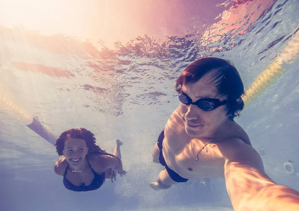 Zwembad. Een man en een vrouw zwemmen in het zwembad voor de — Stockfoto