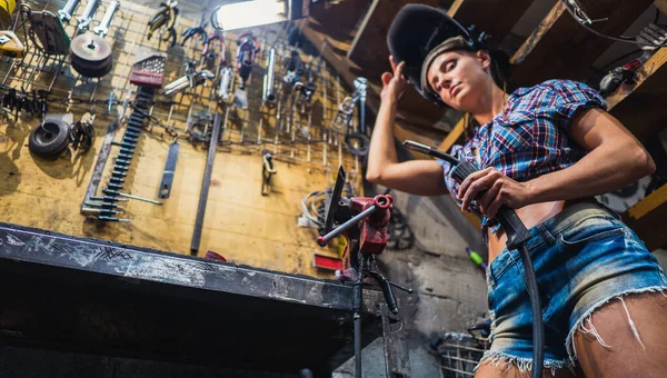 Menina soldadora. Uma menina com uma máquina de solda solda metal . — Fotografia de Stock