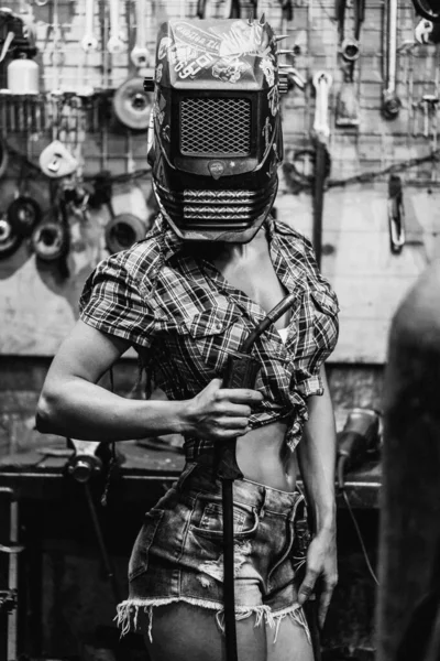 Κορίτσι με συγκολλητή. Ένα κορίτσι με μηχανή συγκόλλησης συγκολλά μέταλλο. — Φωτογραφία Αρχείου