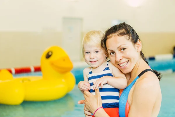 Piscina. Mamá enseña a un niño pequeño a nadar en la piscina . — Foto de Stock