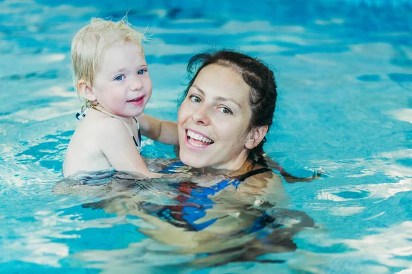 Piscina. Mamá enseña a un niño pequeño a nadar en la piscina . — Foto de Stock