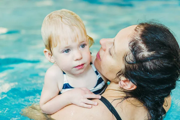 Basen. Mama uczy młodego dziecka, aby pływać w basenie. — Zdjęcie stockowe
