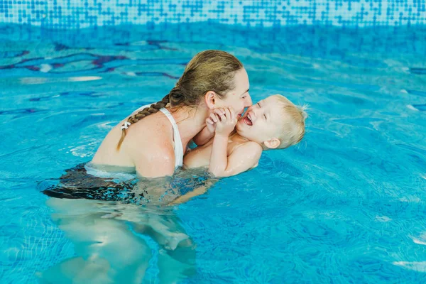 Zwembad. Moeder leert een jong kind om te zwemmen in het zwembad. — Stockfoto