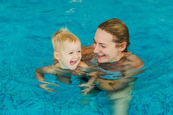 Bazén. Máma učí mladé dítě plavat v bazénu. — Stock fotografie