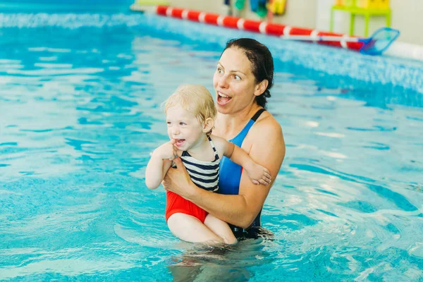 Piscina. Mamma insegna a un bambino a nuotare in piscina . — Foto Stock