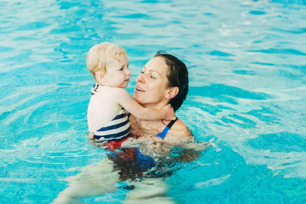 Piscina. Mamá enseña a un niño pequeño a nadar en la piscina . — Foto de Stock