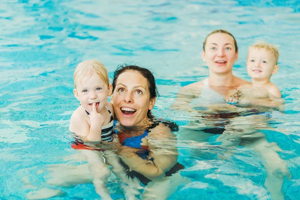 Zwembad. Moeders leren jonge kinderen om te zwemmen. — Stockfoto