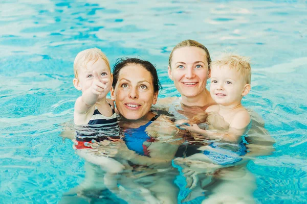 Swimming pool. Moms teach young children to swim.