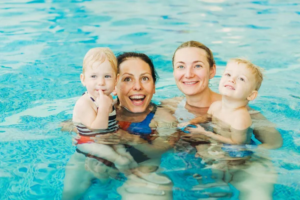 Bazén. Maminky učí mladé děti plavat. — Stock fotografie