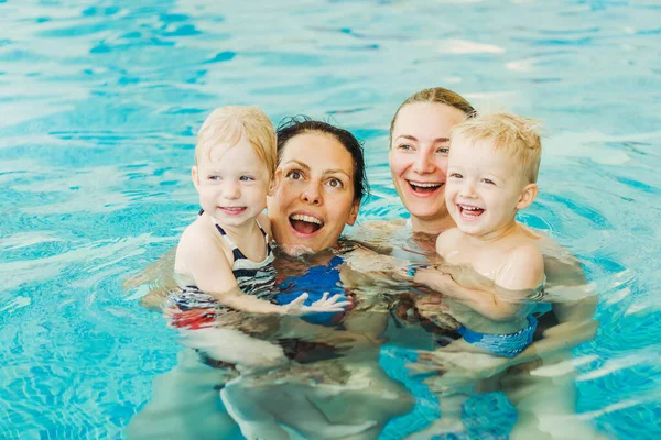 Piscina. Las mamás enseñan a los niños pequeños a nadar . — Foto de Stock